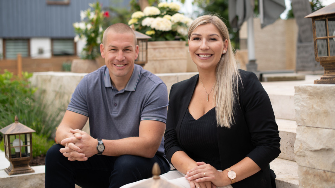 Jan Rohde, Immobilienmakler in Kassel und seine Frau Sabine Rohde, Immobilienmaklerin in Kassel sitzen auf einer Steintreppe im Garten